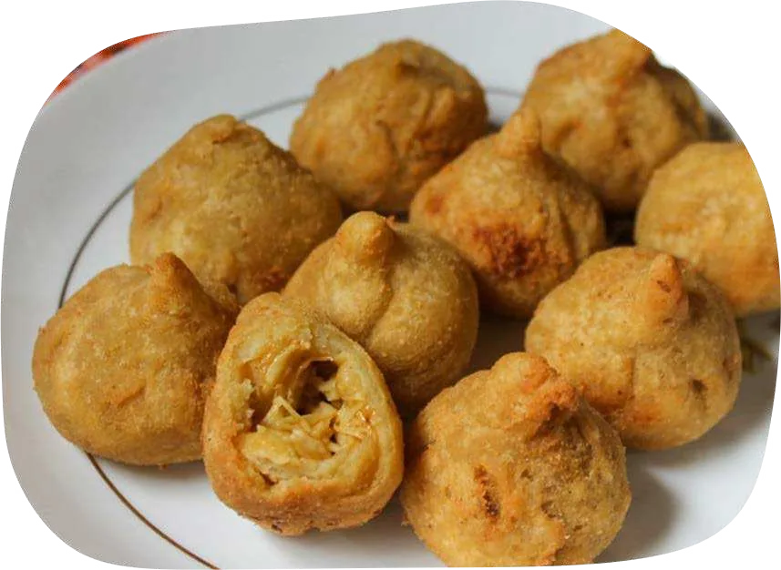 Coxinhas douradas de eryngui em prato, uma delas aberta mostrando o recheio.