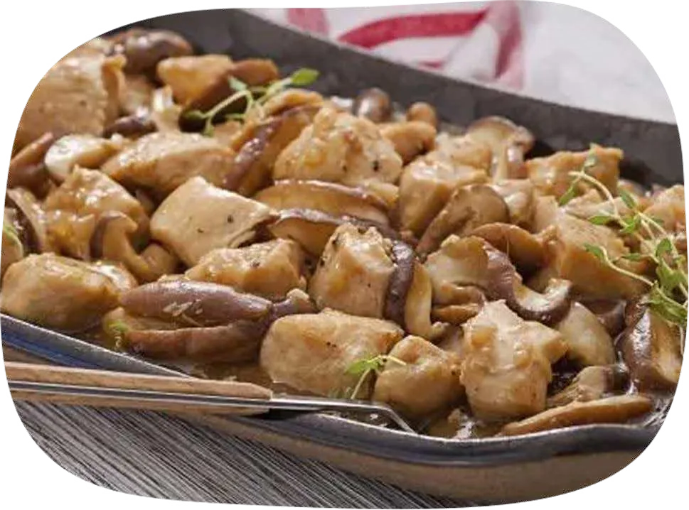 Travessa com cubos de frango e shitake em molho, decorada com tomilho.