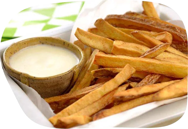 Tigelinha de molho claro e cremoso ao lado de batatas fritas.