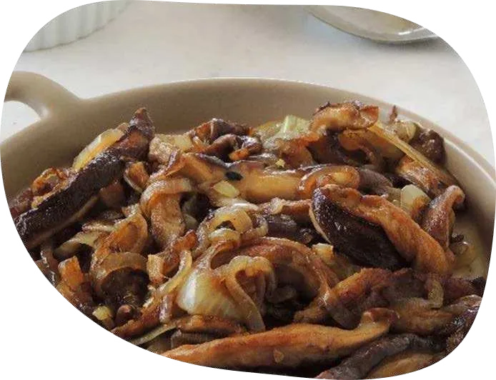 Shitake em tiras refogado com cebola dourada em travessa branca.